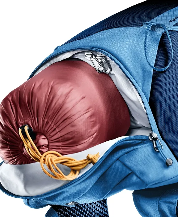 Geöffnetes Hauptfach eines blauen Deuter-Rucksacks mit eingepackten roten Schlafsack.